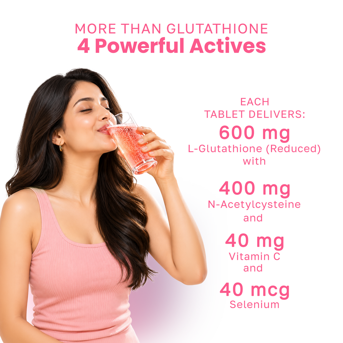 A woman in a pink tank top drinks from a glass of pink liquid on a white background 